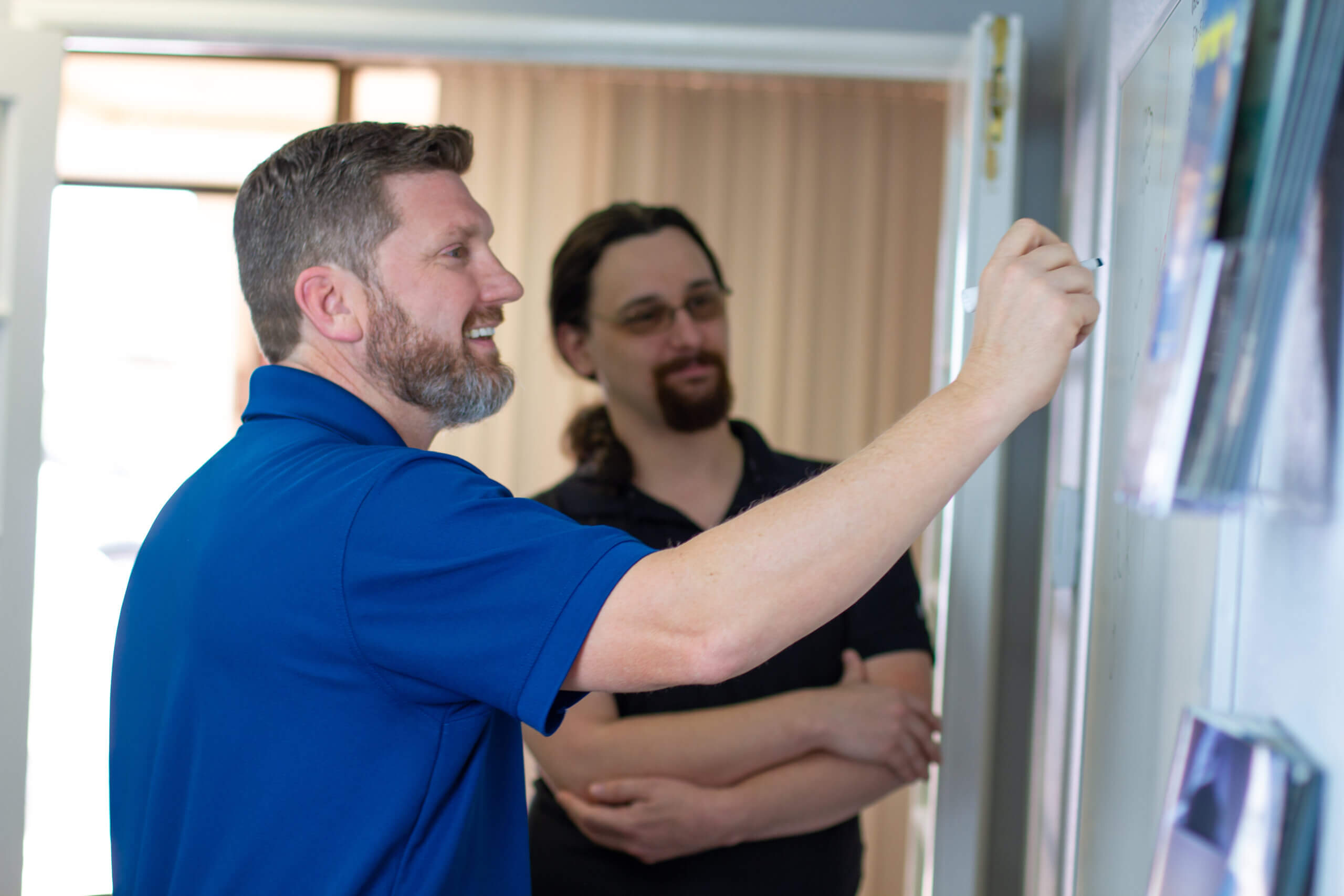 IT Professionals Strategizing Managed IT Services On Whiteboard